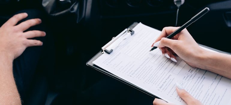 Two people in a car going over documents