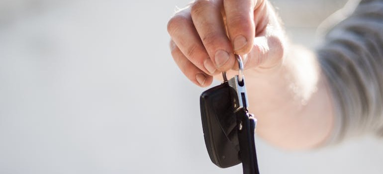 A person giving car keys to another person after learning how to move a car