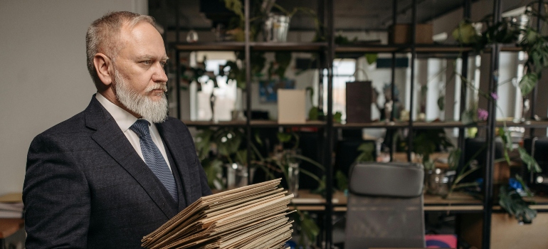 A man is holding a pile of documents in his hands.
