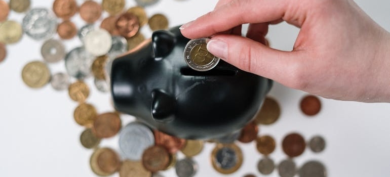 a person putting their money into a piggy bank