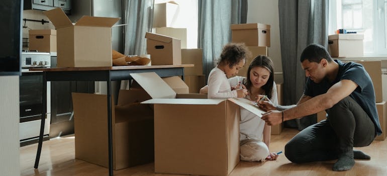 Family unpacking boxes in a new home after moving