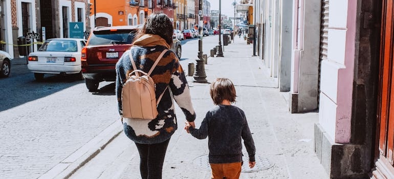 Mom and kid walking down a bustling New York City street
