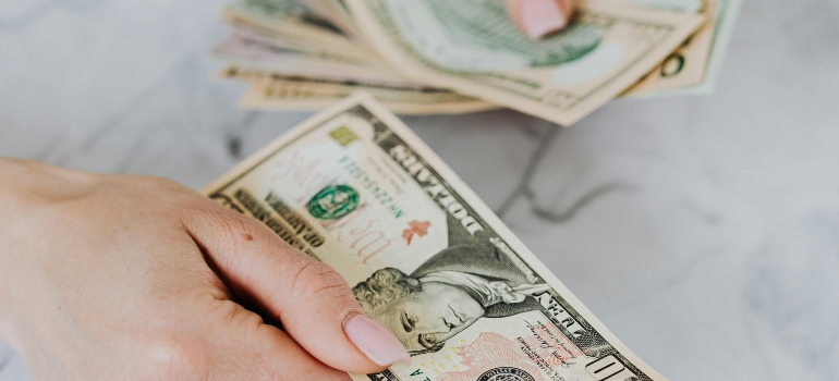 Person counting money when considering insurance.