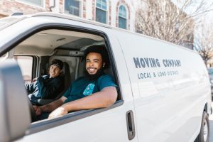two guys in a moving truck getting ready to help people with moving from New Jersey to Florida