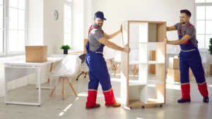 Professional corporate relocation service providers wrap an office chair in protective plastic.