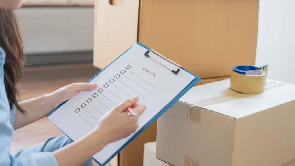 Woman finalizes her checklist and reviews list of moving tips on a clipboard.